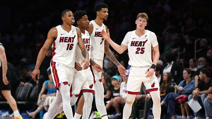 Oct 8, 2025; Miami, Florida, USA;  Miami Heat guard Kasparas Jakucionis (25) is congratulated by forward Keshad Johnson (16), forward Myron Gardner (15) and center Kel'El Ware (7) during a timeout in the second half against the San Antonio Spurs at Kaseya Center. Mandatory Credit: Jim Rassol-Imagn Images