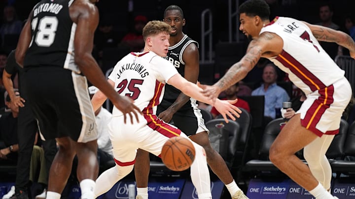 Oct 8, 2025; Miami, Florida, USA;  San Antonio Spurs forward David Jones Garcia (25) threads a pass to center Bismack Biyombo (18) as Miami Heat guard Kasparas Jakucionis (25) and center Kel'El Ware (7) defend during the second half at Kaseya Center. Mandatory Credit: Jim Rassol-Imagn Images