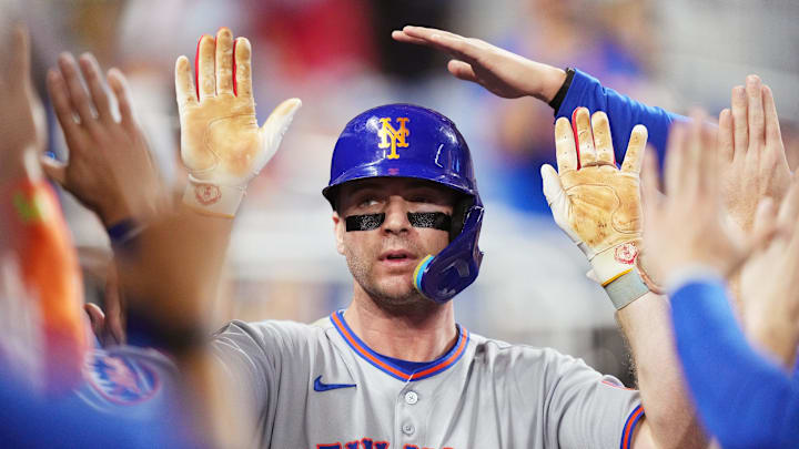 Pete Alonso high-fiving teammates after hitting a home run. Pete Alonso high-fiving teammates after hitting a home run.