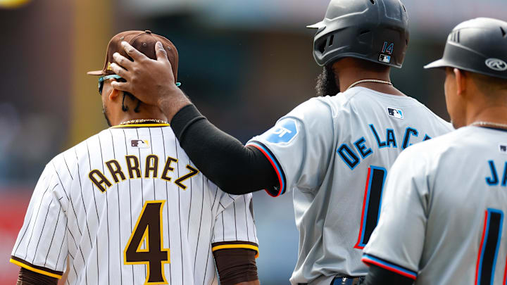 May 27, 2024; San Diego, California, USA;  Miami Marlins designated hitter Bryan De La Cruz (14) embraces his former teammate San Diego Padres first baseman Luis Arraez (4) at first base after hitting a single in the first inning against the San Diego Padres at Petco Park. Mandatory Credit: David Frerker-USA TODAY Sports