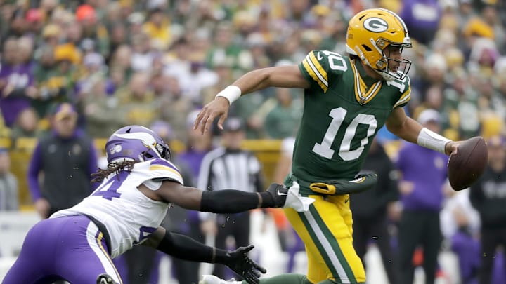 Oct 29, 2023; Green Bay, Wisconsin, USA; Green Bay Packers quarterback Jordan Love (10) is chased by Minnesota Vikings safety Josh Metellus (44) during their football game at Lambeau Field.