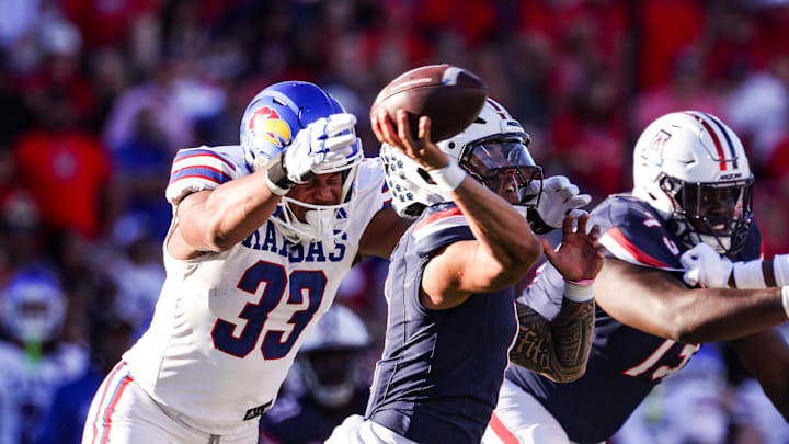 Nov 8, 2025; Tucson, Arizona, USA; Arizona Wildcats quarterback Noah Fifita (1) throws a pass before he gets tackled Kansas Jayhawks defensive end Leroy Harris III (33) during the fourth quarter of the game at Arizona Stadium. Mandatory Credit: Aryanna Frank-Imagn Images
