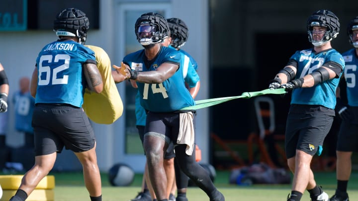 Jacksonville Jaguars offensive tackle Walker Little (72) holds back offensive tackle Cam Robinson (74) as he goes up against guard Samuel Jackson (62) in drills during the Jacksonville Jaguars Thursday morning training camp session July 27, 2023 inside the Miller Electric Center training facility.