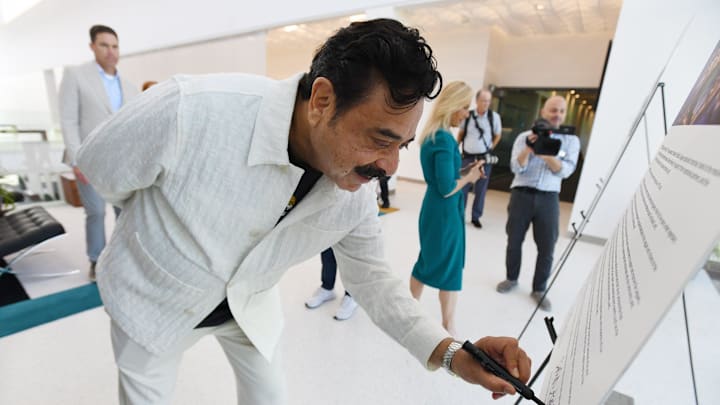 Jacksonville Jaguars owner Shad Khan signs copies of a proclamation on the newly approved stadium renovation deal.