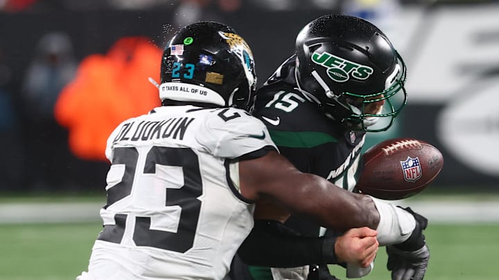 Dec 22, 2022; East Rutherford, New Jersey, USA; Jacksonville Jaguars linebacker Foyesade Oluokun (23) forces a fumble by New York Jets quarterback Chris Streveler (15) during the second half at MetLife Stadium. Mandatory Credit: Ed Mulholland-Imagn Images