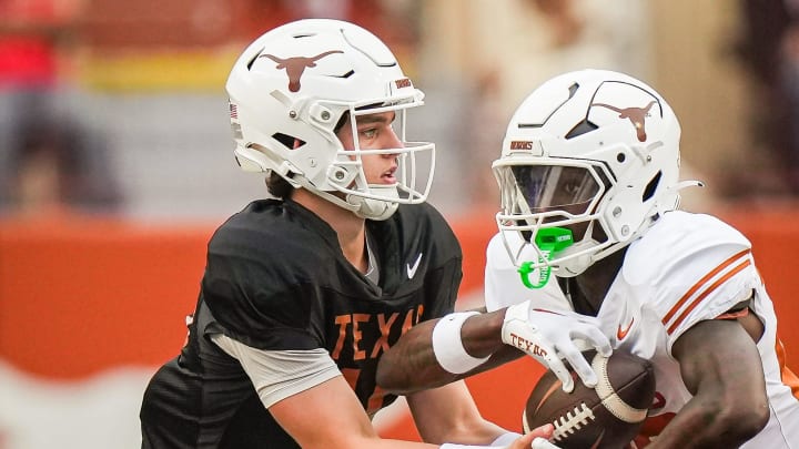 Texas Longhorns quarterback Arch Manning (16) hands the ball of to Texas White team running back Quintrevion Wisner (26) in the second quarter of the Longhorns' spring Orange and White game at Darrell K Royal Texas Memorial Stadium in Austin, Texas, April 20, 2024.