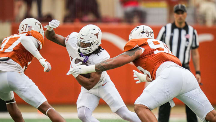 Texas White team running back Jaydon Blue (23) navigates between defense from Texas Orange linebacker Morice Blackwell Jr. (37) and defensive lineman Tiaoalii Savea (98) in the second quarter of the Longhorns' spring Orange and White game at Darrell K Royal Texas Memorial Stadium in Austin, Texas, April 20, 2024.