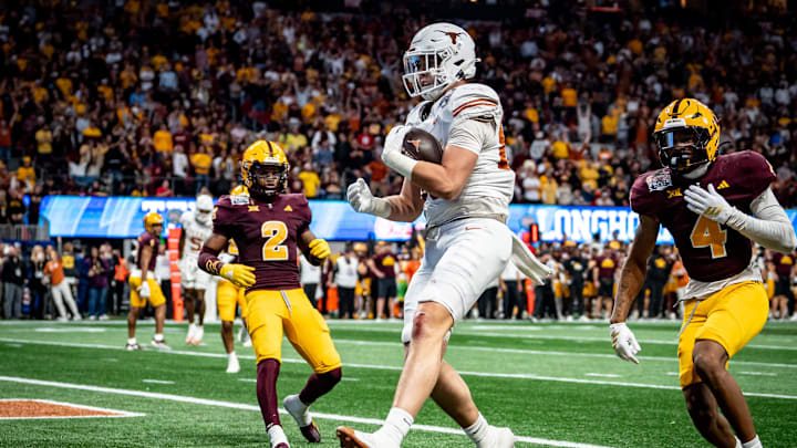 Texas Longhorns tight end Gunnar Helm (85) catches a pass to score a touchdown, evading defense from Arizona State Sun Devils defensive back Myles Rowser (4), during the second overtime period as the Texas Longhorns play the Arizona State Sun Devils in the Peach Bowl College Football Playoff quarterfinal at Mercedes-Benz Stadium in Atlanta, Georgia, Jan. 1, 2025.