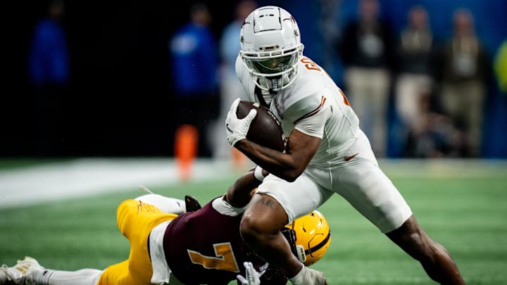 Texas Longhorns wide receiver Matthew Golden (2) evades a tackle from Arizona State Sun Devils defensive back Shamari Simmons (7) in the fourth quarter as the Texas Longhorns play the Arizona State Sun Devils in the Peach Bowl College Football Playoff quarterfinal at Mercedes-Benz Stadium in Atlanta, Georgia, Jan. 1, 2025.