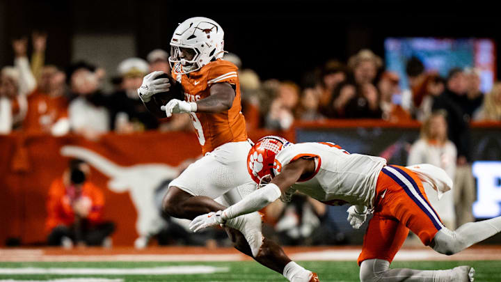 Dec 21, 2024; Austin, Texas, USA; Texas Longhorns running back Jerrick Gibson (9) evades a tackle against Clemson Tigers Tigers safety R.J. Mickens (9) in the fourth quarter at Darrell K Royal Texas Memorial Stadium. Mandatory Credit: Sara Diggins/USA Today Network via Imagn Images