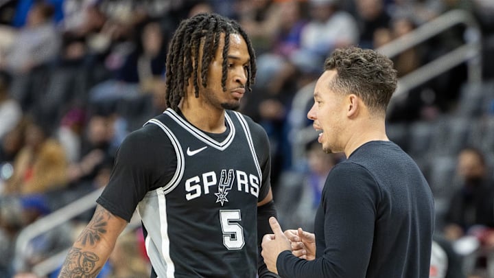 Mar 25, 2025; Detroit, Michigan, USA; San Antonio Spurs assistant coach Mitch Johnson talks to guard Stephon Castle (5) on a play stoppage against the Detroit Pistons during the first half at Little Caesars Arena. Mandatory Credit: David Reginek-Imagn Images