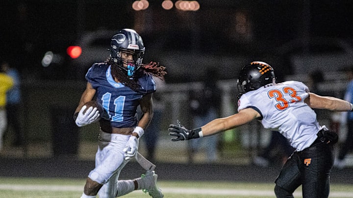 Guilford running back Messiah Tilson runs past Freeport's Riley Rushing during the first half of their game at Guilford High School in Rockford. Guilford running back Messiah Tilson runs past Freeport's Riley Rushing during the first half of their game at Guilford High School in Rockford.
