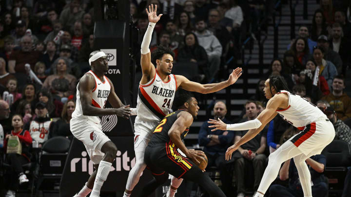 Mar 13, 2024; Portland, Oregon, USA; Atlanta Hawks guard Trent Forrest is triple teamed by Dalano Banton and his Portland Trail Blazers colleagues.