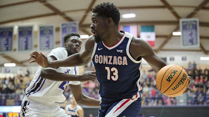 Jan 25, 2025; Portland, Oregon, USA; Gonzaga Bulldogs forward Graham Ike (13) drives to the basket during the first half against Portland Pilots forward Bol Dengdit (24) at Chiles Center. Mandatory Credit: Troy Wayrynen-Imagn Images