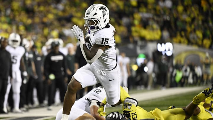 Oct 4, 2024; Eugene, Oregon, USA; Michigan State Spartans running back Kay'Ron Lynch-Adams (15) breaks away from Oregon Ducks defensive back Dakoda Fields (11) during the second half at Autzen Stadium. Mandatory Credit: Troy Wayrynen-Imagn Images