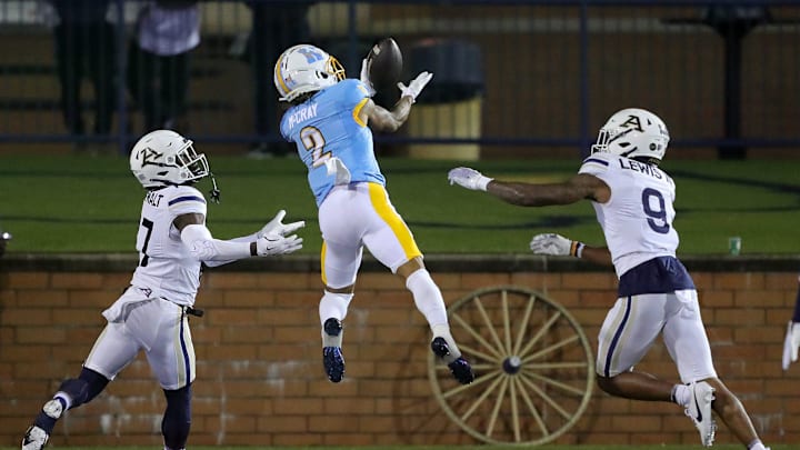 Kent State wide receiver Chrishon McCray catches a second-half touchdown pass between Akron defensive backs Malcom DeWalt IV (left) and Paul Lewis III, Tuesday, Nov. 19, 2024, in Kent.