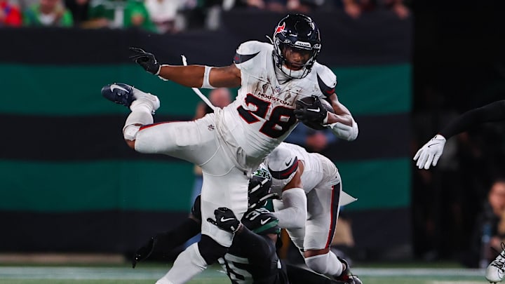 Oct 31, 2024; East Rutherford, New Jersey, USA; Houston Texans running back Joe Mixon (28) runs with the ball while Houston Texans linebacker Jake Hansen (35) attempts to tackle him during the first half at MetLife Stadium. Mandatory Credit: Ed Mulholland-Imagn Images