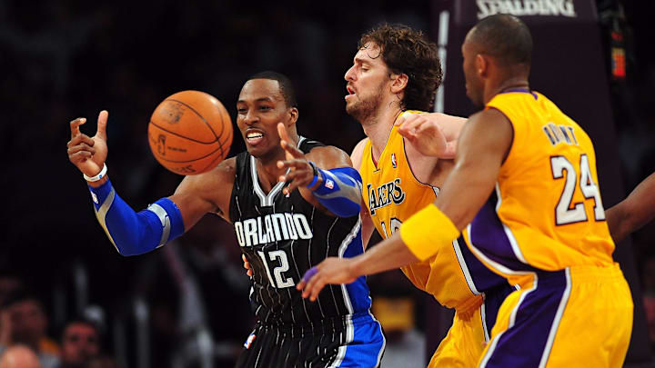 March 14, 2011; Los Angeles, CA, USA; Orlando Magic center Dwight Howard (12) loses control of the ball against the defense of Los Angeles Lakers power forward Pau Gasol (center) and shooting guard Kobe Bryant (24) during the second half at the Staples Center. Mandatory Credit: Gary A. Vasquez-Imagn Images