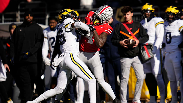 Michigan Wolverines defensive back Jyaire Hill (35) tackles Ohio State Buckeyes wide receiver Jeremiah Smith (4) during the first half of the NCAA football game at Ohio Stadium in Columbus on Saturday, Nov. 30, 2024.