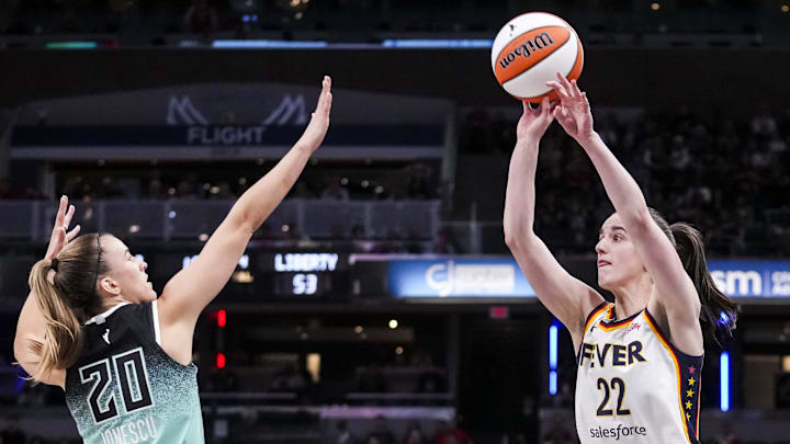 May 24, 2025; Indianapolis, Indiana, USA; Indiana Fever guard Caitlin Clark (22) attempts a 3-pointer against New York Liberty guard Sabrina Ionescu (20) on during a game between the Indiana Fever and the New York Liberty at Gainbridge Fieldhouse. Mandatory Credit: Grace Smith/USA Today Network via Imagn Images May 24, 2025; Indianapolis, Indiana, USA; Indiana Fever guard Caitlin Clark (22) attempts a 3-pointer against New York Liberty guard Sabrina Ionescu (20) on during a game between the Indiana Fever and the New York Liberty at Gainbridge Fieldhouse. Mandatory Credit: Grace Smith/USA Today Network via Imagn Images
