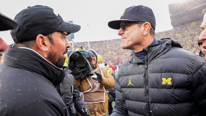 Coaches Ryan Day of Ohio State and Jim Harbaugh of Michigan shake hands after the Wolverines' win in 2021.