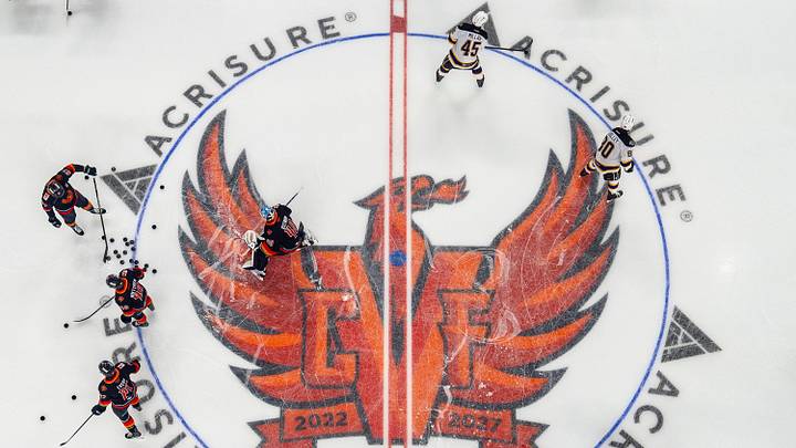 Coachella Valley Firebirds players warm up before their game against the Ontario Reign around the new center logo at Acrisure Arena in Palm Desert, Calif., Friday, Oct. 2, 2026.