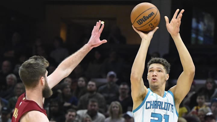 Jan 5, 2025; Cleveland, Ohio, USA; Charlotte Hornets forward Tidjane Salaun (31) shoots beside Cleveland Cavaliers forward Dean Wade (32) in the second quarter at Rocket Mortgage FieldHouse. Mandatory Credit: David Richard-Imagn Images