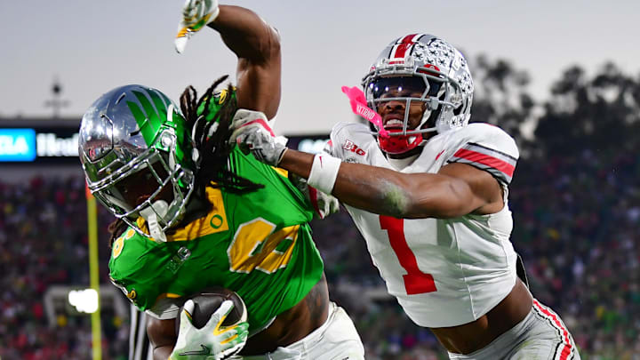 Jan 1, 2025; Pasadena, CA, USA;  Ohio State Buckeyes cornerback Davison Igbinosun (1) pushes Oregon Ducks running back Noah Whittington (6) out of bounds in the second half in the 2025 Rose Bowl college football quarterfinal game at Rose Bowl Stadium. Mandatory Credit: Gary A. Vasquez-Imagn Images