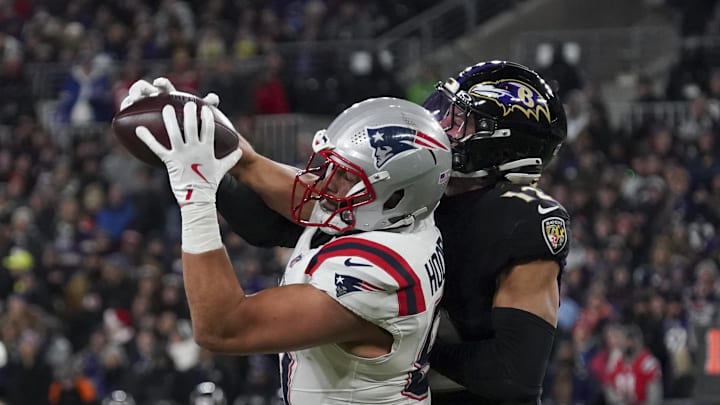Dec 21, 2025; Baltimore, Maryland, USA;  New England Patriots tight end Austin Hooper (81) makes a catch against Baltimore Ravens safety Alohi Gilman (12) during the first half of the game at M&T Bank Stadium. Mandatory Credit: James Lang-Imagn Images