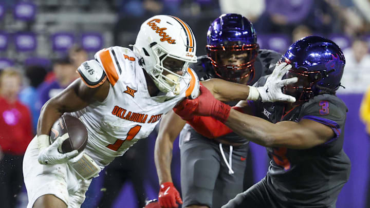 Nov 9, 2024; Fort Worth, Texas, USA;  Oklahoma State Cowboys wide receiver De'Zhaun Stribling (1) stiff arms TCU Horned Frogs linebacker Kaleb Elarms-Orr (3) during the second half at Amon G. Carter Stadium. Mandatory Credit: Kevin Jairaj-Imagn Images