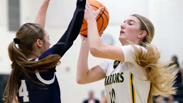 Penn-Trafford's Olivia Weishaar attempts to shoot over West York's Lily Weaver during the first round of the PIAA Class 5A playoffs Saturday in Harrison City. The Warriors beat the Bulldogs to earn their first state playoff win since 2023.