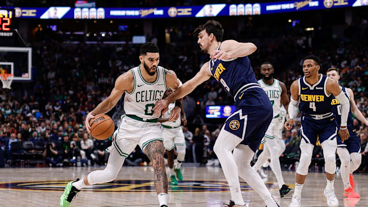 Jan 7, 2025; Denver, Colorado, USA; Boston Celtics forward Jayson Tatum (0) controls the ball as Denver Nuggets forward Dario Saric (9) guards in the third quarter at Ball Arena. Mandatory Credit: Isaiah J. Downing-Imagn Images