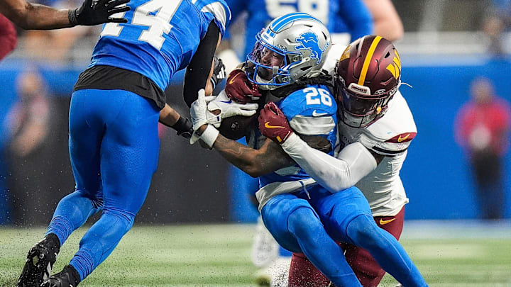 Detroit Lions running back Jahmyr Gibbs (26) is tackled by Washington Commanders safety Jeremy Chinn (11) during the first half of the NFC divisional round at Ford Field in Detroit on Saturday, Jan. 18, 2025.