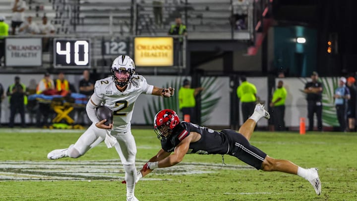 Aug 28, 2025; Orlando, Florida, USA; UCF Knights quarterback Tayven Jackson (2) avoids a tackle during the second quarter against the Jacksonville State Gamecocks at Acrisure Bounce House. Mandatory Credit: Mike Watters-Imagn Images
