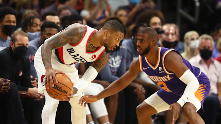 Nov 10, 2021; Phoenix, Arizona, USA; Portland Trail Blazers guard Damian Lillard (0) controls the ball against Phoenix Suns guard Chris Paul in the first half at Footprint Center. Mandatory Credit: Mark J. Rebilas-Imagn Images