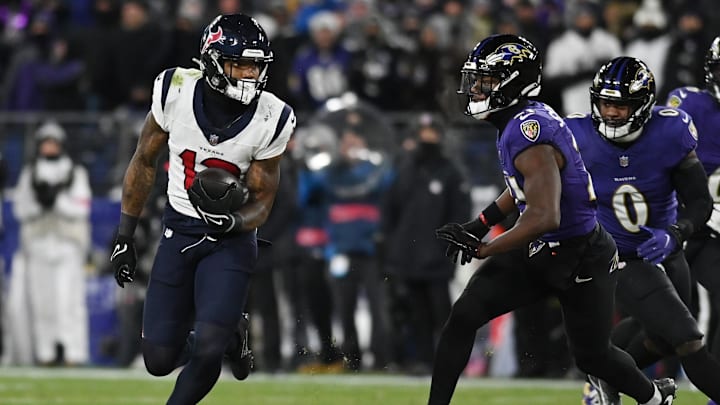 Jan 20, 2024; Baltimore, MD, USA; Houston Texans wide receiver Nico Collins (12) runs the ball against Baltimore Ravens cornerback Brandon Stephens (21) and linebacker Roquan Smith (0) during the second quarter of a 2024 AFC divisional round game at M&T Bank Stadium. Mandatory Credit: Tommy Gilligan-Imagn Images