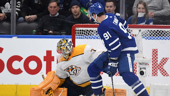 Jan 11, 2023; Toronto, Ontario, CAN; Nashville Predators goaltender Jusse Saros (74) makes a save as Toronto Maple Leafs forward John Tavares (91) looks for the rebound in the second period at Scotiabank Arena. Mandatory Credit: Dan Hamilton-USA TODAY Sports