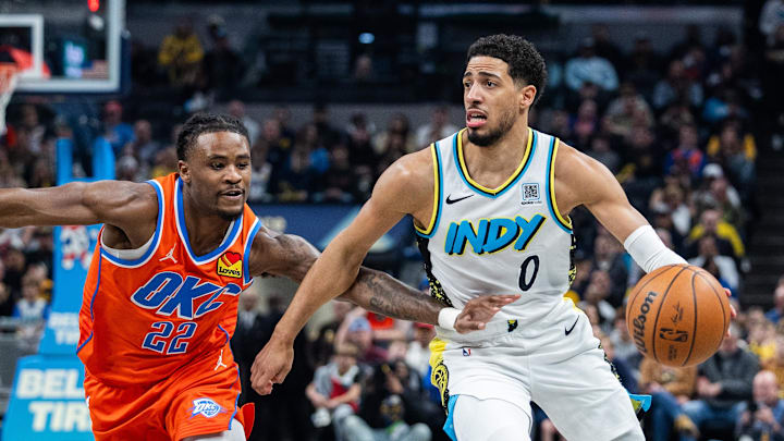 Dec 26, 2024; Indianapolis, Indiana, USA; Indiana Pacers guard Tyrese Haliburton (0) dribbles the ball while Oklahoma City Thunder guard Cason Wallace (22) defends in the first half at Gainbridge Fieldhouse. Mandatory Credit: Trevor Ruszkowski-Imagn Images
