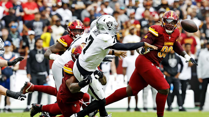 Sep 21, 2025; Landover, Maryland, USA; Las Vegas Raiders quarterback Geno Smith (7) makes a pass during the second half as Washington Commanders nose tackle Daron Payne (94) defends at Northwest Stadium. Mandatory Credit: Geoff Burke-Imagn Images