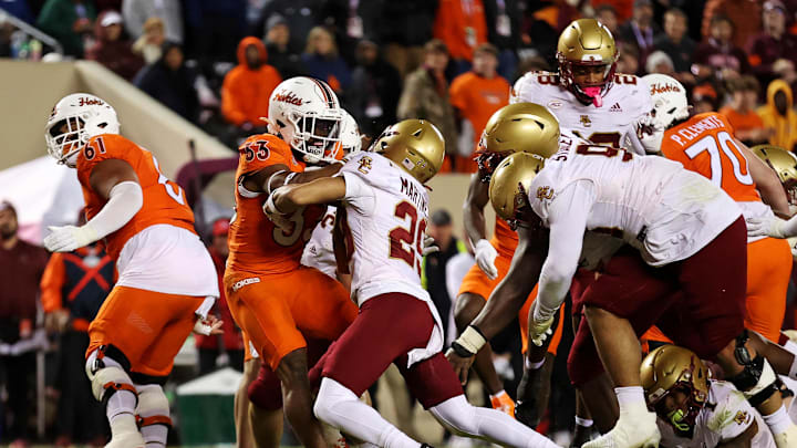 Oct 17, 2024; Blacksburg, Virginia, USA; Virginia Tech Hokies running back Bhayshul Tuten (33) runs for a touchdown against Boston College Eagles defensive back Cameron Martinez (29) during the fourth quarter at Lane Stadium. Mandatory Credit: Peter Casey-Imagn Images