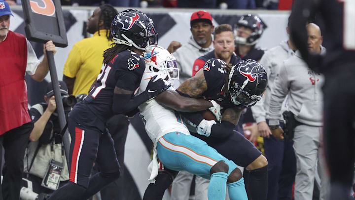 Dec 15, 2024; Houston, Texas, USA; Miami Dolphins wide receiver Tyreek Hill (10) attempts to strip the ball from Houston Texans cornerback Derek Stingley Jr. (24) after an interception during the fourth quarter at NRG Stadium. 