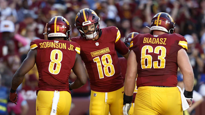 Oct 20, 2024; Landover, Maryland, USA; Washington Commanders running back Brian Robinson Jr. (8) celebrates with Commanders quarterback Marcus Mariota (18) after scoring a touchdown against the Carolina Panthers during the second quarter at Northwest Stadium. Mandatory Credit: Geoff Burke-Imagn Images