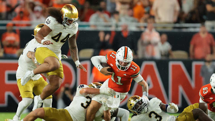 Aug 31, 2025; Miami Gardens, Florida, USA; Miami Hurricanes quarterback Carson Beck (11) rushes the ball against the Notre Dame Fighting Irish during the second quarter at Hard Rock Stadium. Mandatory Credit: Sam Navarro-Imagn Images