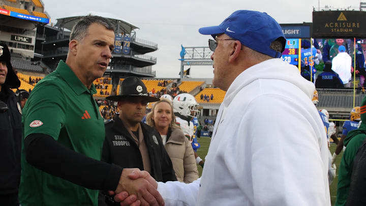 Nov 29, 2025; Pittsburgh, Pennsylvania, USA; Miami Hurricanes head coach Mario Cristobal (left) and Pittsburgh Panthers head coach Pat Narduzzi (right) shake hands after their game at Acrisure Stadium. Mandatory Credit: Charles LeClaire-Imagn Images Nov 29, 2025; Pittsburgh, Pennsylvania, USA; Miami Hurricanes head coach Mario Cristobal (left) and Pittsburgh Panthers head coach Pat Narduzzi (right) shake hands after their game at Acrisure Stadium. Mandatory Credit: Charles LeClaire-Imagn Images