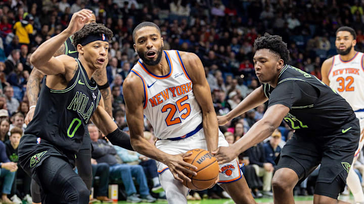 Dec 29, 2025; New Orleans, Louisiana, USA;  New York Knicks guard/forward Mikal Bridges (25) dribbles against New Orleans Pelicans center Derik Queen (22) and guard Jeremiah Fears (0) during the first half at Smoothie King Center. Mandatory Credit: Stephen Lew-Imagn Images