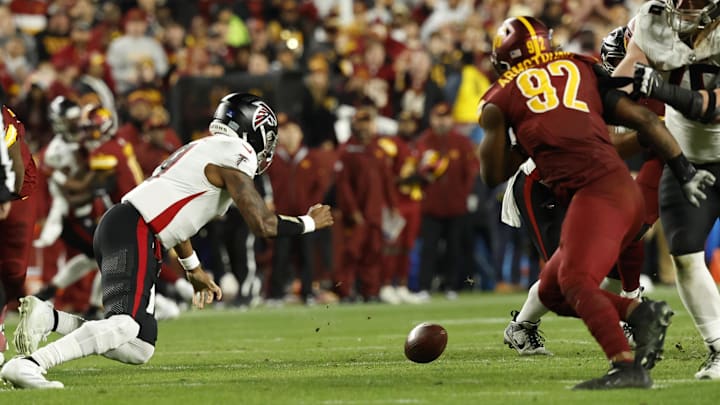 Dec 29, 2024; Landover, Maryland, USA; Atlanta Falcons quarterback Michael Penix Jr. (9) dives to recover his fumble as Washington Commanders defensive end Dorance Armstrong (92) chases during the third quarter at Northwest Stadium. Mandatory Credit: Geoff Burke-Imagn Images