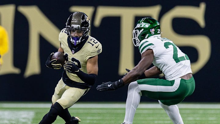 Dec 21, 2025; New Orleans, Louisiana, USA;  New Orleans Saints wide receiver Chris Olave (12) catches a pass and is chased out of bounds bye New York Jets cornerback Brandon Stephens (21) during the first half  at Caesars Superdome. Mandatory Credit: Stephen Lew-Imagn Images