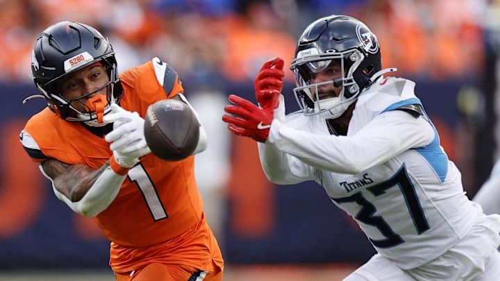 Sep 7, 2025; Denver, Colorado, USA; Tennessee Titans safety Amani Hooker (37) knocks the ball away from Denver Broncos tight end Evan Engram (1) in the first half at Empower Field at Mile High. 