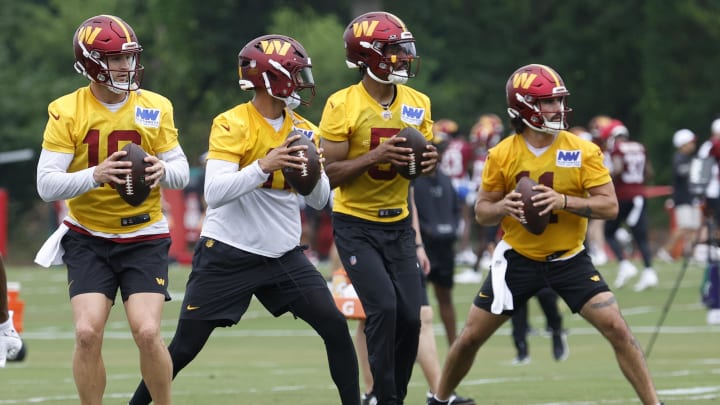 Jun 5, 2024; Ashburn, VA, USA; (L-R) Washington Commanders quarterback Jeff Driskel (16), Commanders quarterback Marcus Mariota (0), Commanders quarterback Jayden Daniels (5), and Commanders quarterback Sam Hartman (11) drop back to pass during an OTA workout at Commanders Park. Mandatory Credit: Geoff Burke-USA TODAY Sports