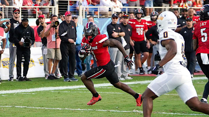 Dec 23, 2025; Boca Raton, FL, USA; Louisville Cardinals running back Isaac Brown (1) rushes for a touchdown during the fourth quarter of the Boca Raton Bowl at Flagler CU Stadium. Mandatory Credit: Jeff Romance-Imagn Images
